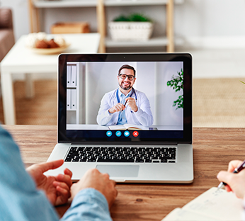 Casal realiza consulta online com computador em casa