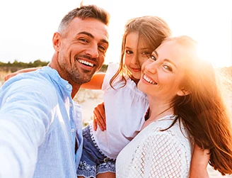 Pai, mãe e filha sorrindo, apresentando saúde bucal com planos odontológicos individuais e para empresas.