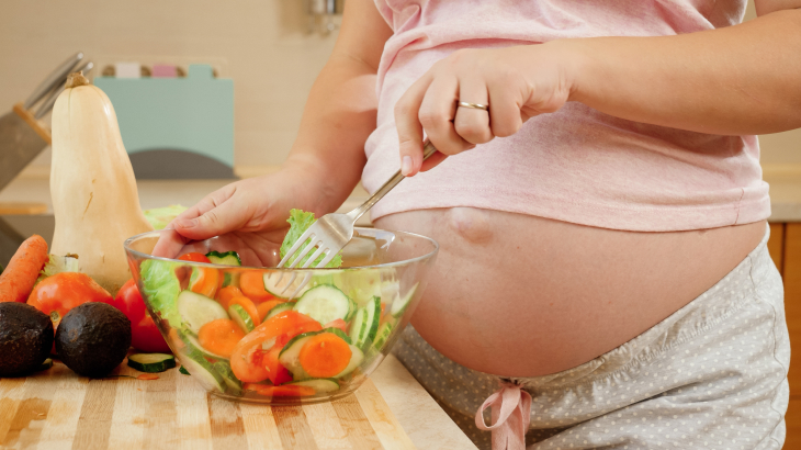 Mulher grávida preparando uma salada