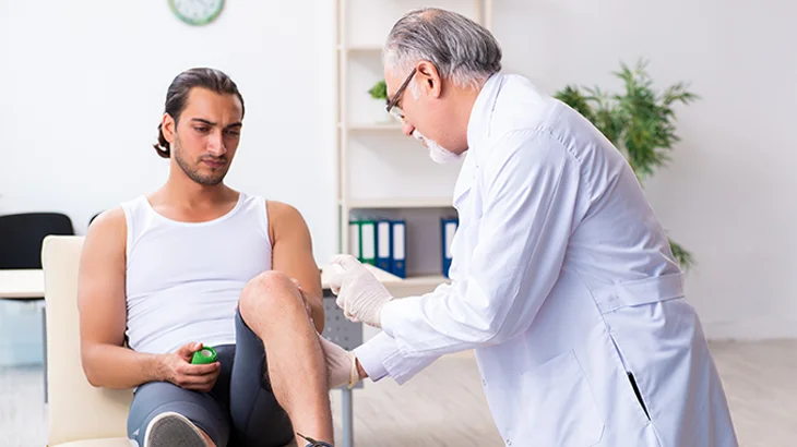 Homem avaliando o joelho com médico
