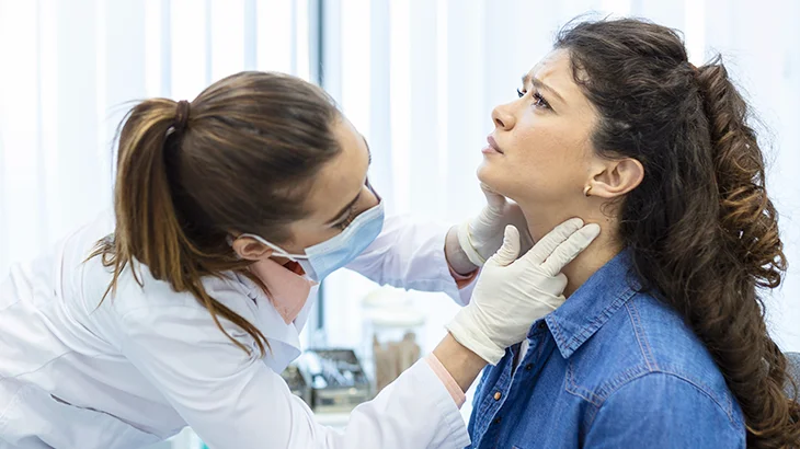 Médica analisando o pescoço da paciente
