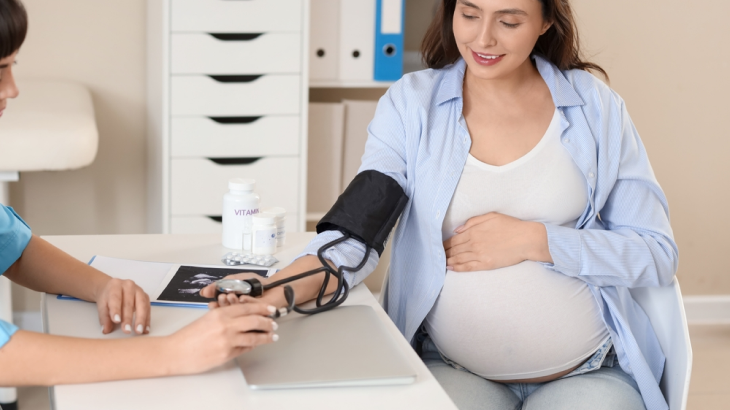 Mulher grávida sentada com a mão na barriga