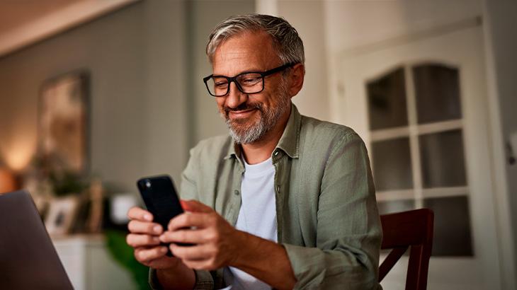 Homem segurando o celular e olhando para tela