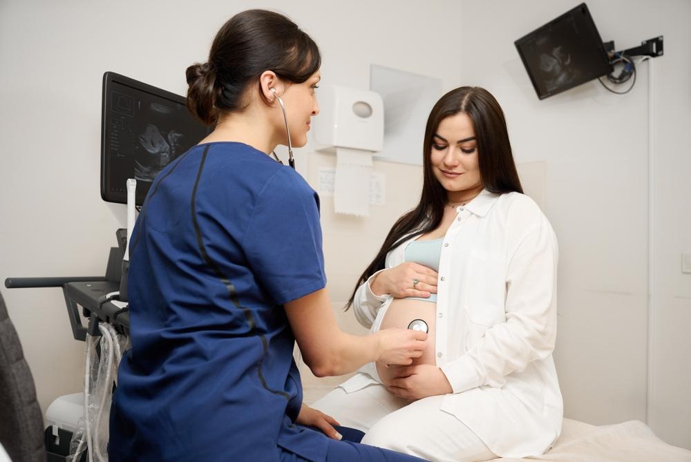 Gestante sendo examinada por profissional de saúde durante o pré-natal, representando cuidados para lidar com inchaço na gravidez e dores comuns na gestação.