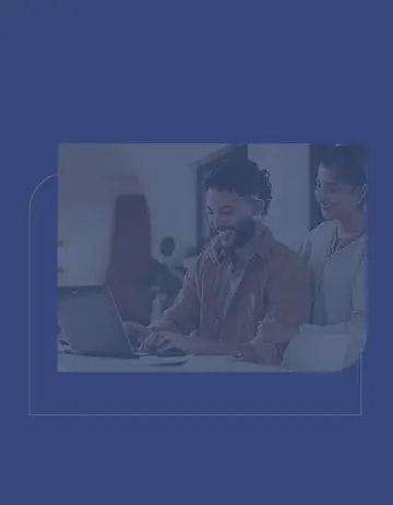 Duas pessoas em casa, sorrindo e colaborando, usam um notebook em um ambiente claro e acolhedor, transmitindo parceria e tranquilidade.