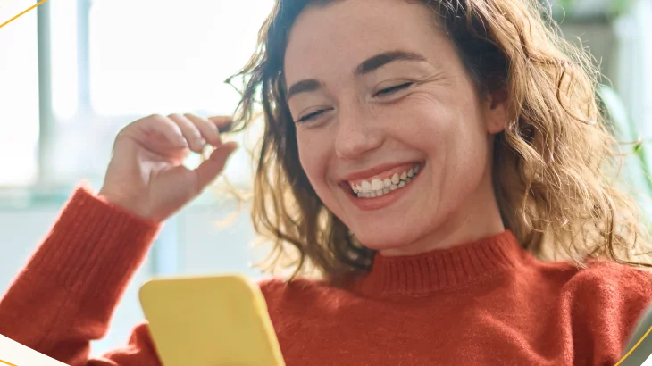 Mulher sorrindo mexendo no celular