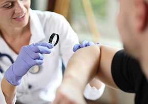 Médica examina pele de paciente